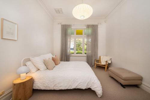 Carnegie的住宿－Timeless Gem in Malvern East，卧室配有床、椅子和窗户。