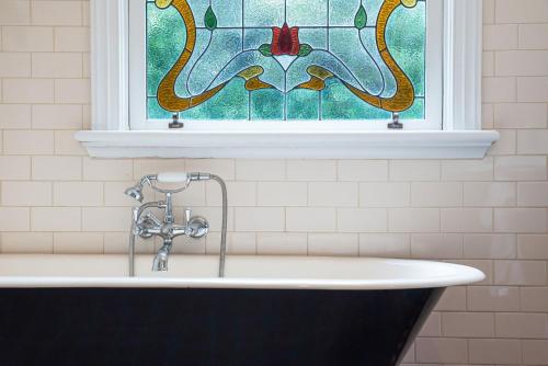Carnegie的住宿－Timeless Gem in Malvern East，浴缸上方设有彩色玻璃窗