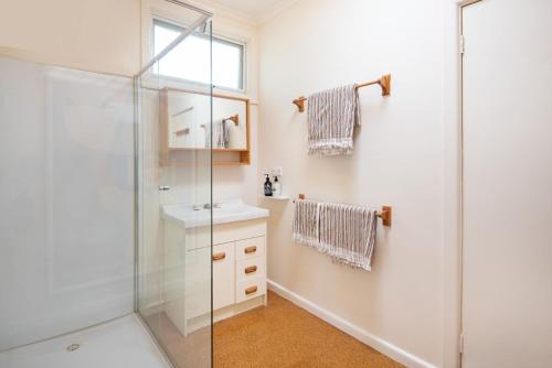 a bathroom with a shower and a sink at Bessie at Merricks Beach in Coles Beach