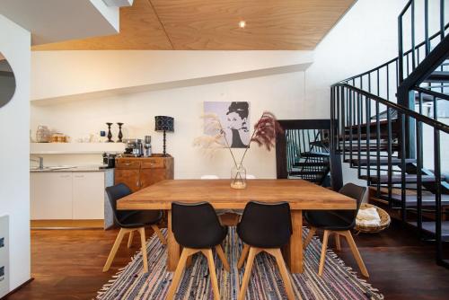 a dining room with a wooden table and chairs at Loft Living Close to the MCG in Melbourne