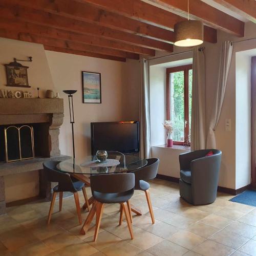 a living room with a table and chairs and a fireplace at Le Grand Domaine du Rocher in Bonnemain
