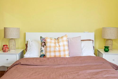 a bedroom with a bed with pillows and two lamps at Retro Beach Babe 100 metres to the beach in Tootgarook