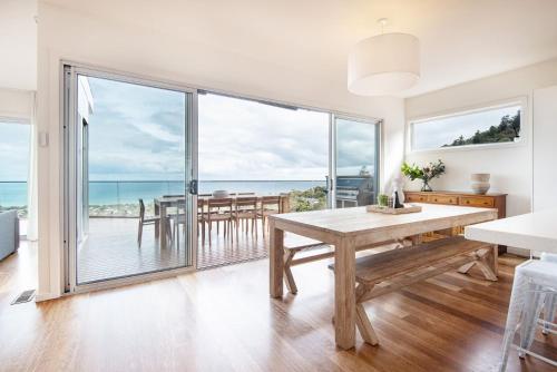 a dining room with a table and a view of the ocean at Cook's Lookout McCrae in McCrae