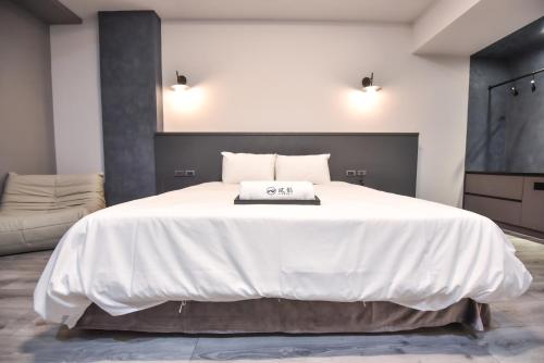 a bedroom with a large white bed and a flat screen tv at Two Couples Leisure Art Motel in Tainan