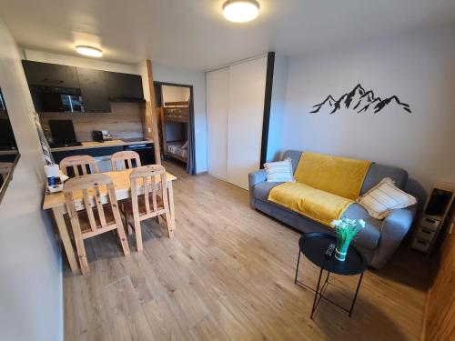 ein Wohnzimmer mit einem Sofa und einem Tisch in der Unterkunft Studio cosy de 23 m2 à la montagne in Samoëns