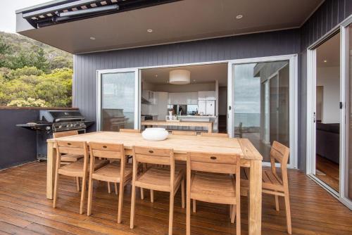 a kitchen and dining room with a wooden table and chairs at Cook's Lookout McCrae in McCrae