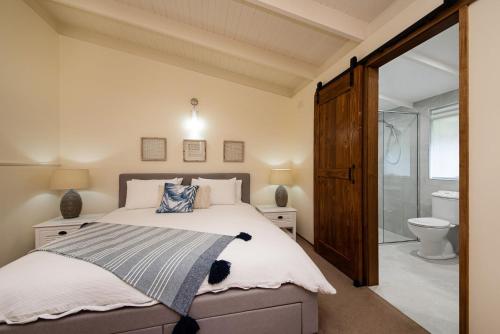 a bedroom with a large bed and a shower at Dromanas Beachside Hideaway in Dromana