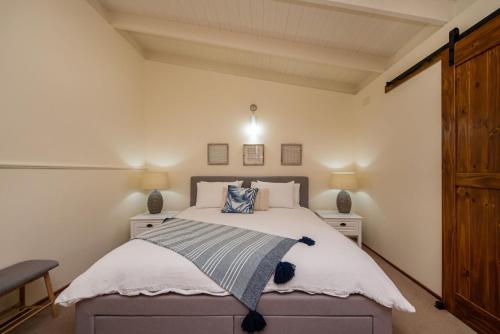 a bedroom with a bed and two night stands at Dromanas Beachside Hideaway in Dromana