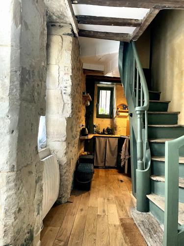 einen Flur mit einer Steinmauer und einer Treppe in einem Zimmer in der Unterkunft Tour St Sauveur in Bellême