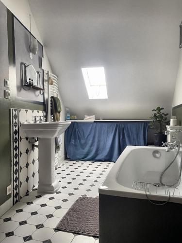 ein Badezimmer mit einer weißen Badewanne und einem Waschbecken in der Unterkunft Tour St Sauveur in Bellême