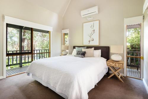 een slaapkamer met een groot bed en een balkon bij Collins Street House in Red Hill in Red Hill