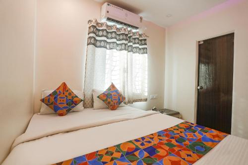 um quarto com uma cama e uma janela em FabExpress Shivas Inn em Nagpur