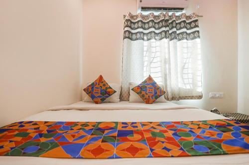 a bedroom with a bed with a colorful quilt on it at FabExpress Shivas Inn in Nagpur