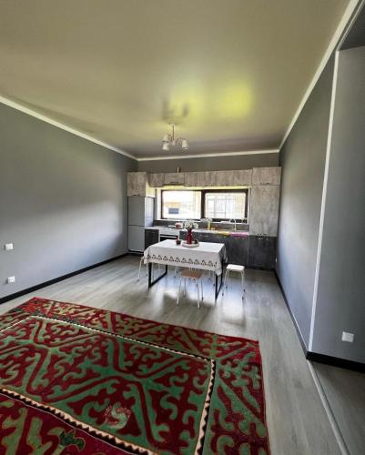 ein Esszimmer mit einem Tisch und einem roten Teppich in der Unterkunft Коттедж в отеле Палм Бич Иссык Куль in Chok-Tal