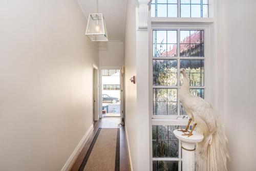 a white bird statue sitting on a toilet in a hallway at Sandy Village Retreat Heated Pool Bay Views in Sandringham