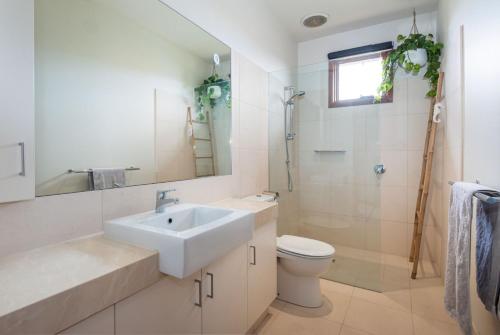 a bathroom with a sink and a toilet and a mirror at Bayside Oasis in Highett in Highett