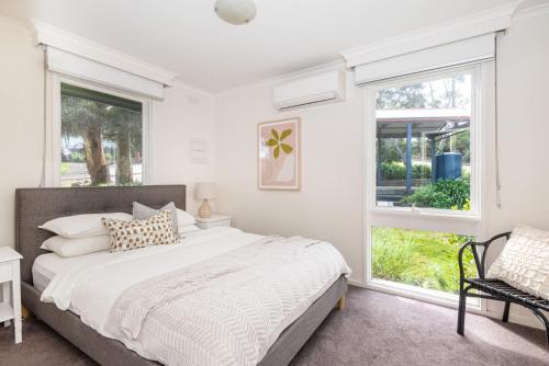 un dormitorio con una cama y una ventana en Bay Views From Drury Lane with Solar Heated Pool and Gas Heated Spa, en Dromana