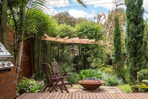 a garden with two chairs and a pergola at Bayside Oasis in Highett in Highett