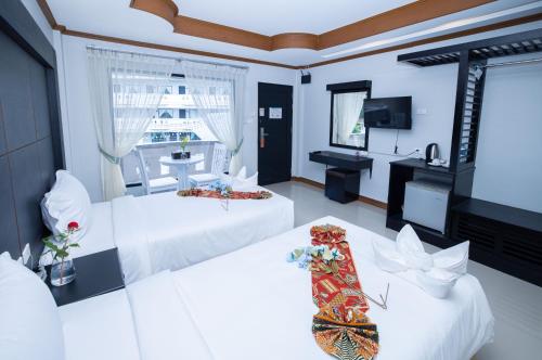 a hotel room with two beds and a television at Blue Carina Hotel Phuket in Phuket Town