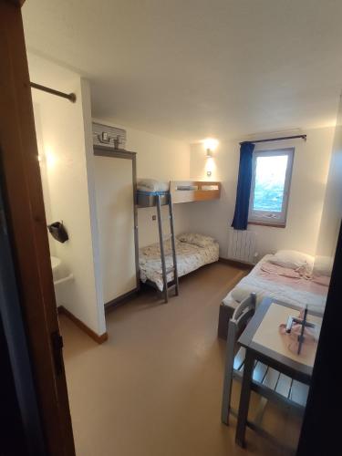 a small room with two beds and a table and a window at Val Louron Pied des pistes apartment 34 m² 5 pers in Génos