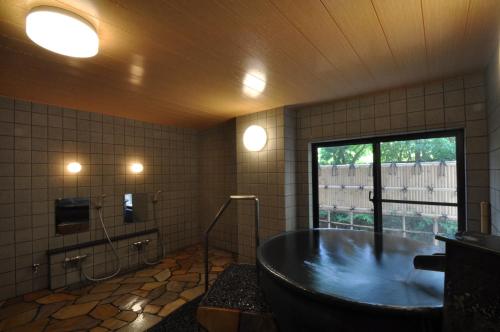 uma grande casa de banho com uma banheira e uma janela em Suikoukan em Hakone