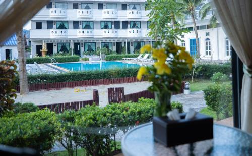 a vase of flowers on a table in front of a building at Blue Carina Hotel Phuket in Phuket Town
