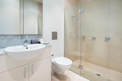 a bathroom with a toilet and a sink and a shower at Grand Victoria Beach House in Melbourne