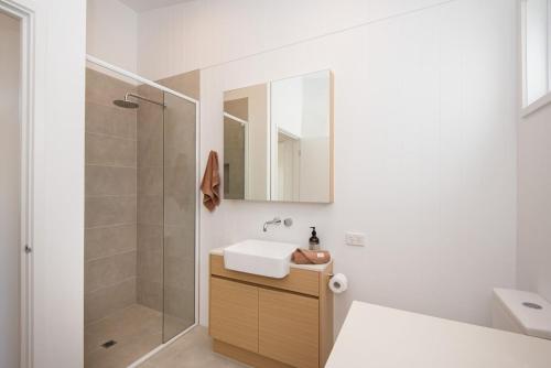 une salle de bain avec un lavabo et une douche dans l'établissement The Snug, à Safety Beach