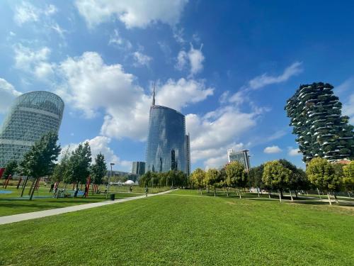 a park in a city with tall buildings at MILA by The Blue Twins apartments Milano in Milan