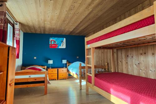 a bedroom with two bunk beds and a blue wall at Chalet Alpina in Les Deux Alpes