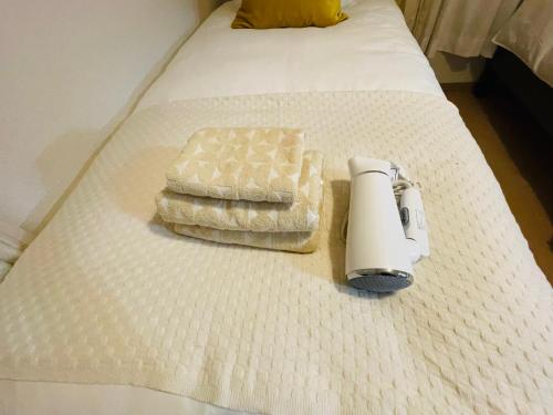 a white bed with two towels on top of it at KANAU in Tokyo