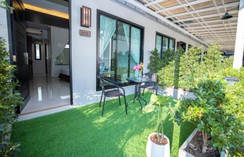 a patio with a table and chairs and plants at Blue Carina Hotel Phuket in Phuket Town
