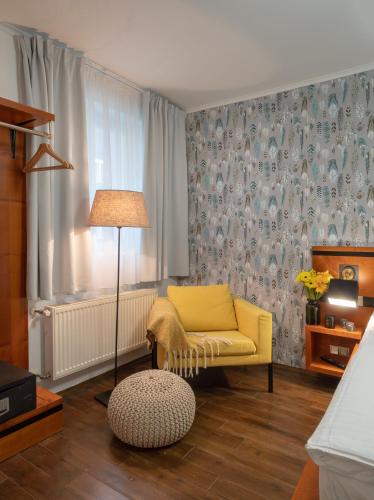 a living room with a yellow chair and a lamp at 4 Elements Apartments in Prague