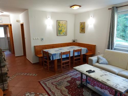 ein Wohnzimmer mit einem Tisch und einem Sofa in der Unterkunft Rogla Apartma Kekec in Vitanje