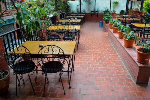 a patio with tables and chairs and potted plants at Thamel Grand Hotel in Kathmandu