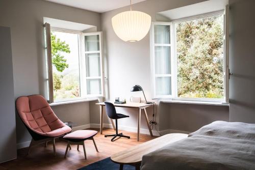 een slaapkamer met een bed, een bureau en 2 stoelen bij Villa Pacini - just 1,8 km outside Lucca Wall - Pool in Lucca