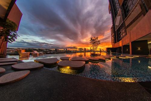 クアラルンプールにあるArte Cheras @ Kuala Lumpurの夕日を背景にプール付きの建物