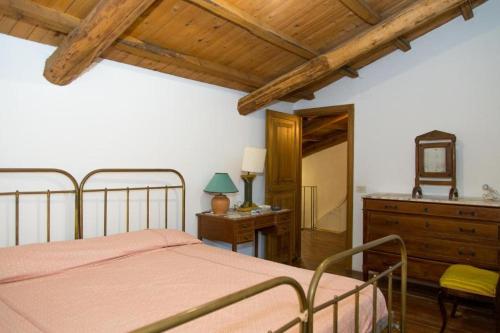 een slaapkamer met een bed en een houten plafond bij All'Alberata in Pescosolido