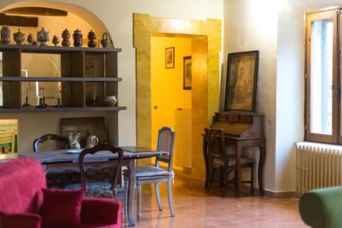 een eetkamer met een tafel en stoelen en een gele muur bij All'Alberata in Pescosolido