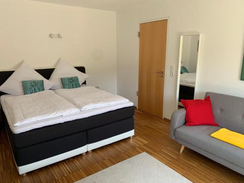 a bedroom with a bed and a couch in it at Panorama Apartment in Kandern