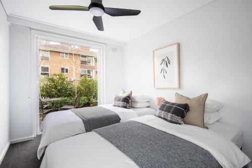 2 camas en una habitación con ventana en South Yarra Oasis Iconic city location, en Melbourne