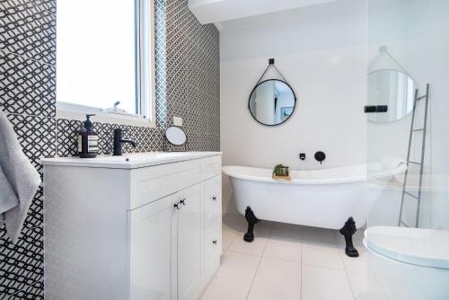 Baño blanco con bañera y lavamanos en South Yarra Oasis Iconic city location, en Melbourne