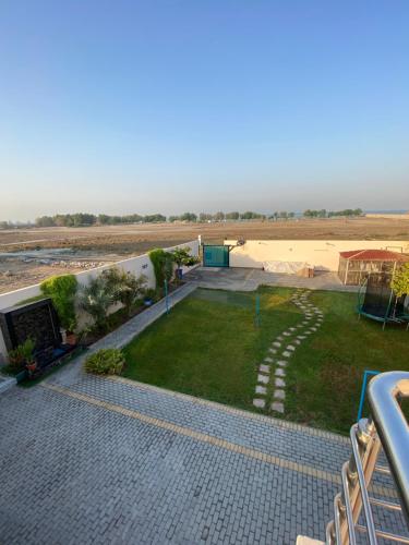 una vista da un balcone di un cortile con un campo di استراحة الساحل a Dumistān