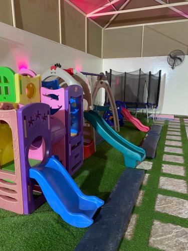 a play room with a slide and play equipment at استراحة الساحل in Dumistān