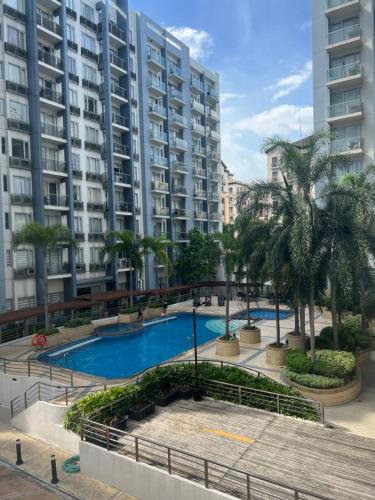 uma piscina em frente a um grande edifício de apartamentos em Vevilyn Condotel em Manila