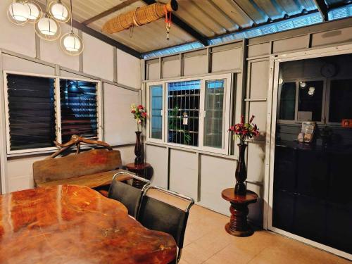 a dining room with a table and some windows at P.California Inter Hostel in Nang Rong