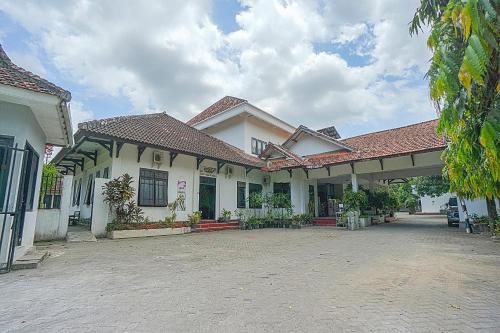 een groot wit gebouw met een grote binnenplaats bij Collection O 90589 Palem Garden Hotel in Tulungagung