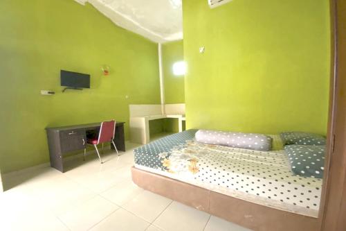 巨港的住宿－OYO Life Afny Kost 1，一间卧室配有一张带绿色墙壁的床