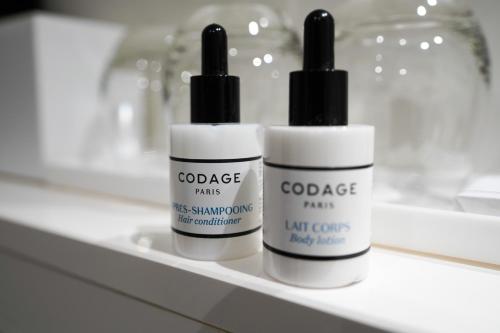 three bottles of sunscreen sitting on a shelf at Hotel Ekta Champs Elysées in Paris