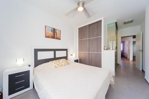 um quarto com uma cama e uma ventoinha de tecto em ALEGRIA ID25 em Playa Flamenca